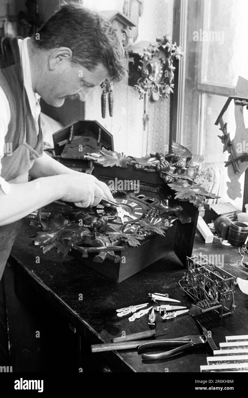 Ein Konstrukteur von Kuckucksuhren bei der Arbeit in seiner Werkstatt, 1938. Ein Konstrukteur von Kuckucksuhren bei der Arbeit in seiner Werkstatt, 1938. Stockfoto