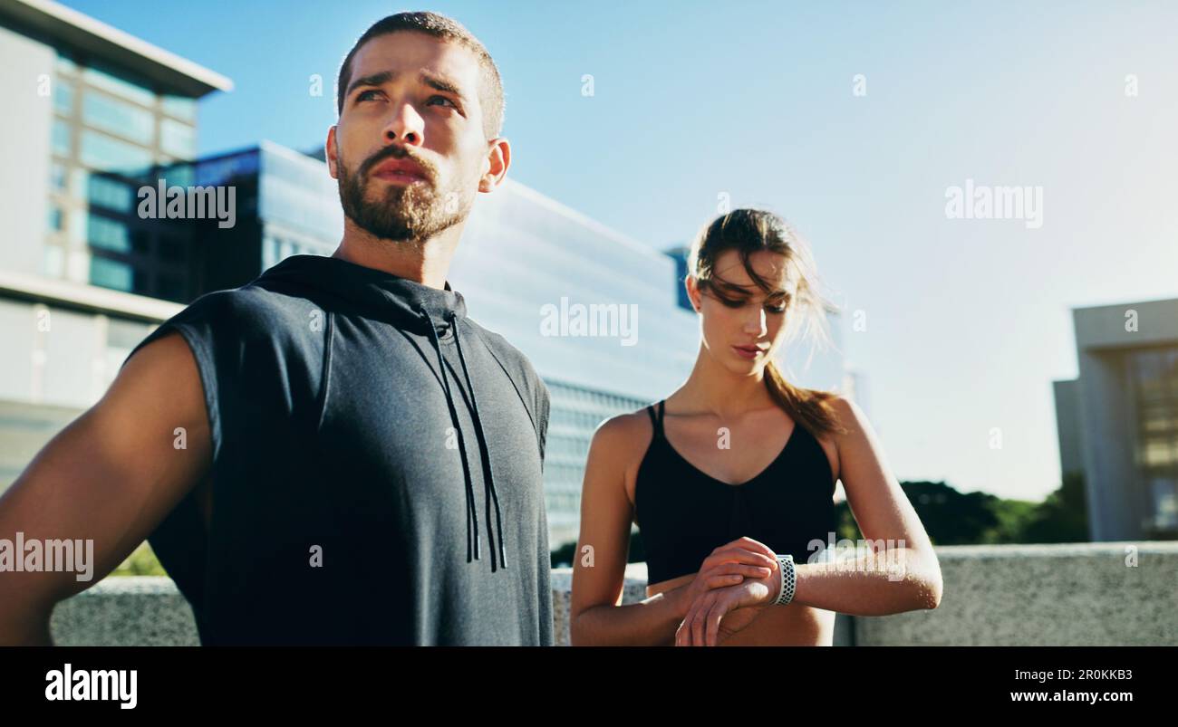 Mit Focus kannst du deine Fitnessziele schnell verfolgen. Ein junges Paar, das zusammen in der Stadt trainiert. Stockfoto