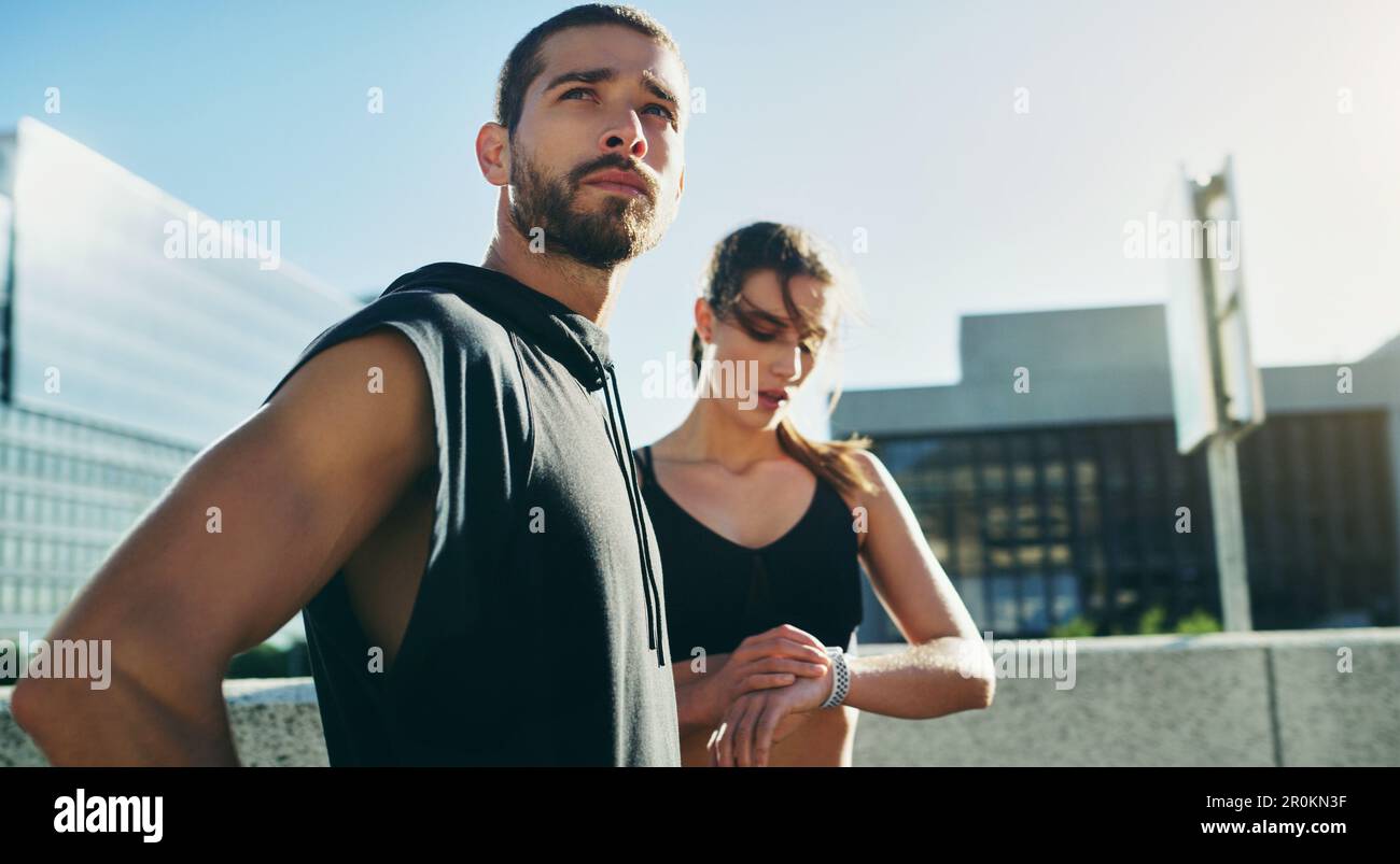 Zeit ist wichtig, nutze sie klug. Ein junges Paar, das zusammen in der Stadt trainiert. Stockfoto