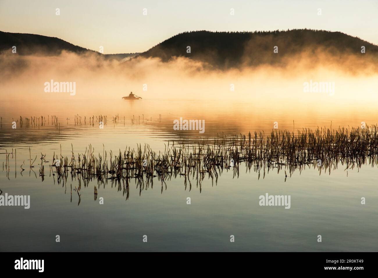 USA, Oregon, Paulina Lake und Brown Cannon – ein Fischer durchquert den frühen Morgennebel in seinem Boot Stockfoto