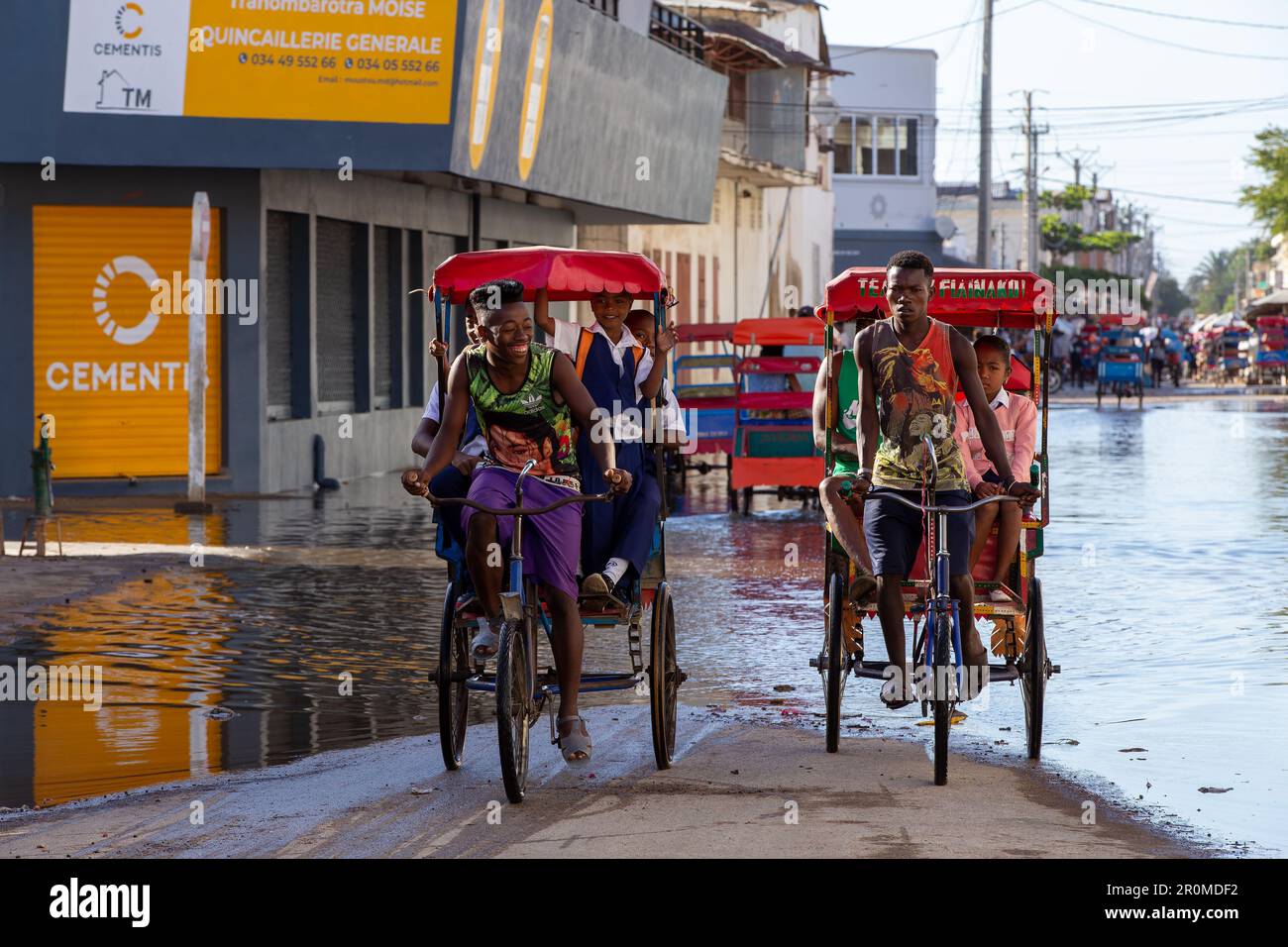 Toliara, Madagaskar - 21. November. 2022: Traditionelles Rikscha-Fahrrad mit madagassischen Passagieren auf der Straße, eine der Möglichkeiten, Geld zu verdienen. Jeden Tag Stockfoto