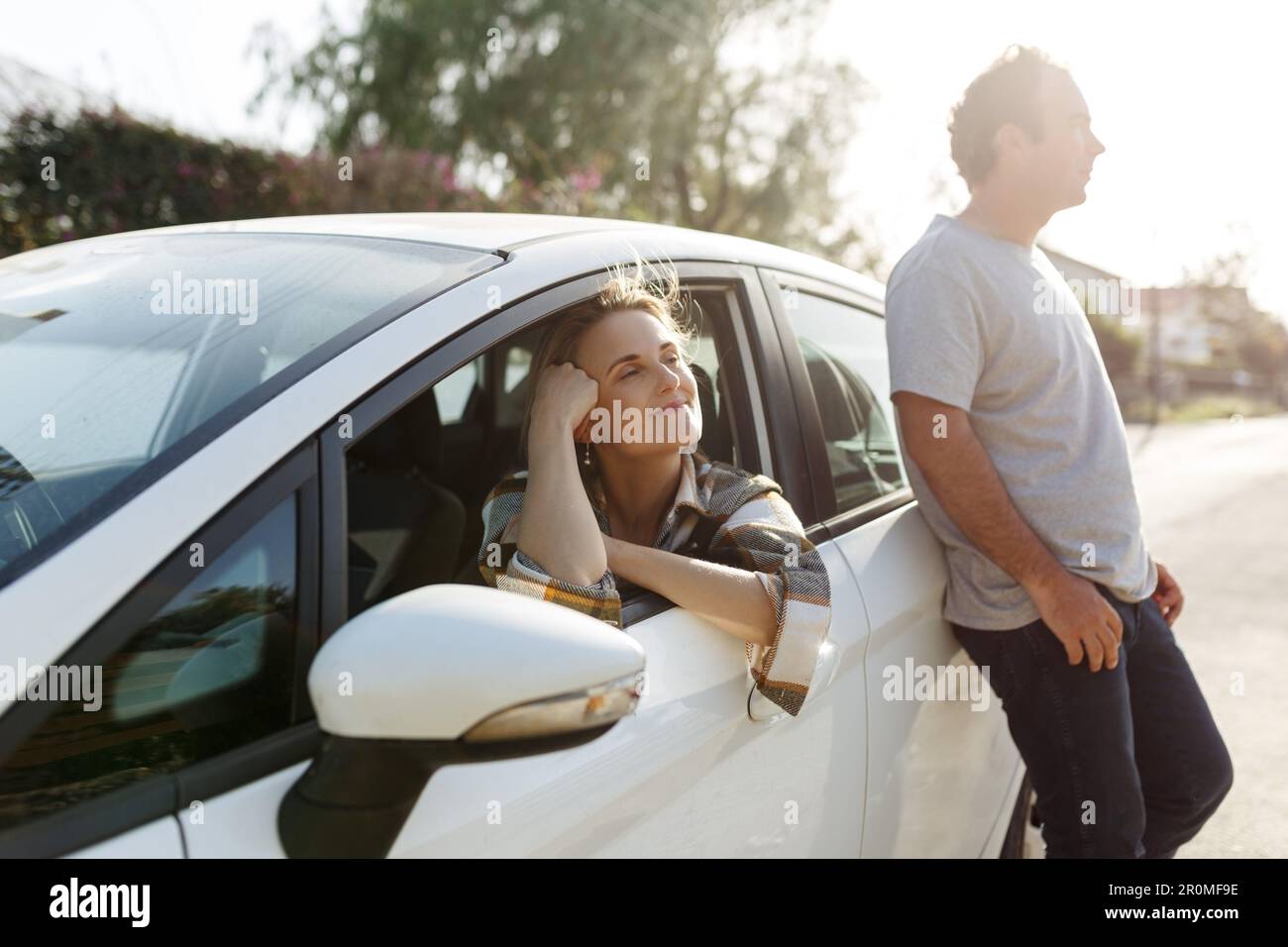 Junge, glückliche Liebhaber, die Spaß auf der Straße haben. Ein Paar, das einen Wanderurlaub macht und mit seinem Auto neue Orte erkundet. Stockfoto