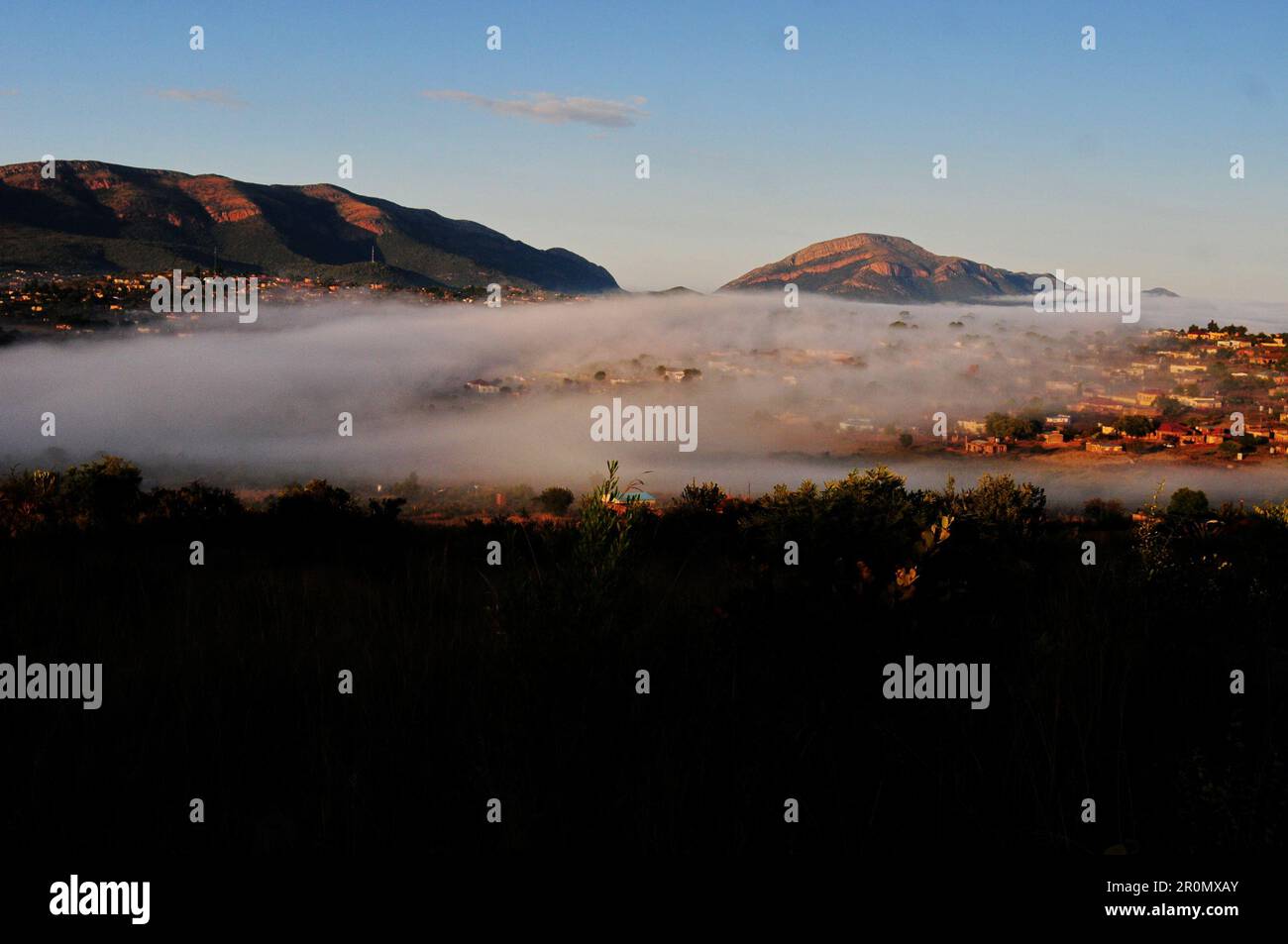 An einem kühlen frühen Wintermorgen schwebt eine Nebeldecke über dem Dorf GA-Maja in der südafrikanischen Provinz Limpopo Stockfoto