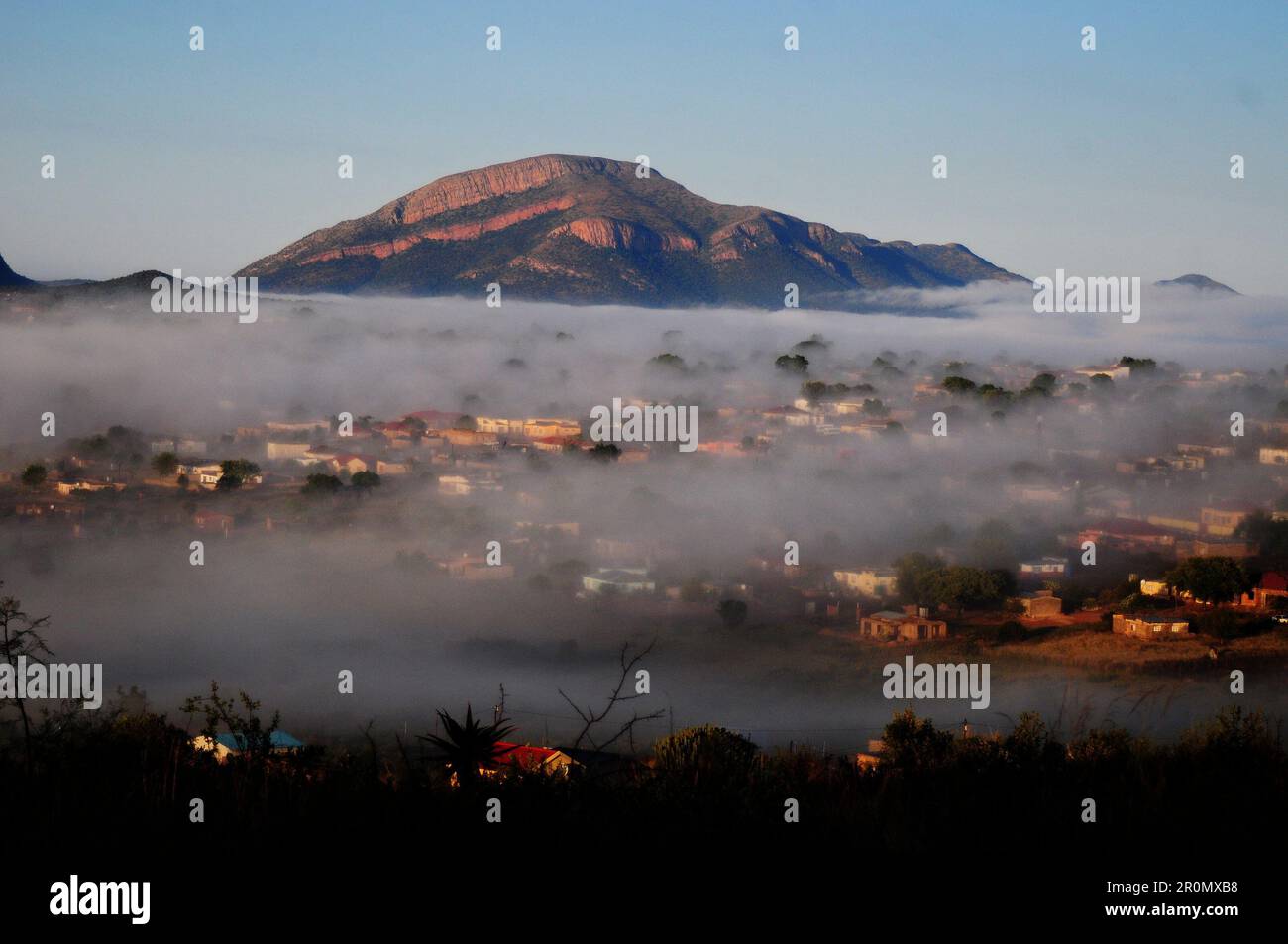 An einem kühlen frühen Wintermorgen schwebt eine Nebeldecke über dem Dorf GA-Maja in der südafrikanischen Provinz Limpopo Stockfoto