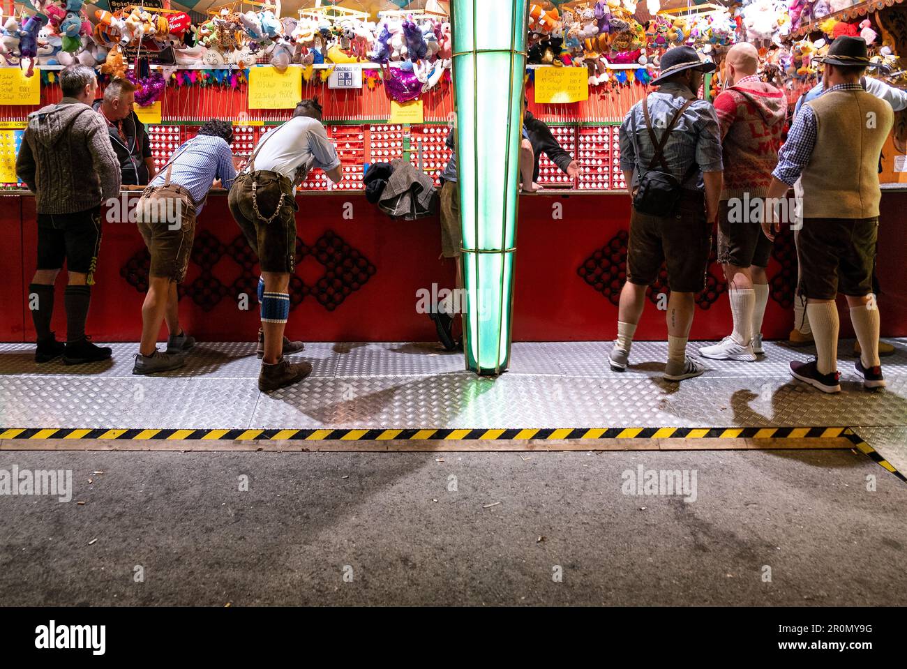 Männer in bayerischem Kostüm auf dem Schießstand beim Oktoberfest, München, Bayern, Deutschland Stockfoto