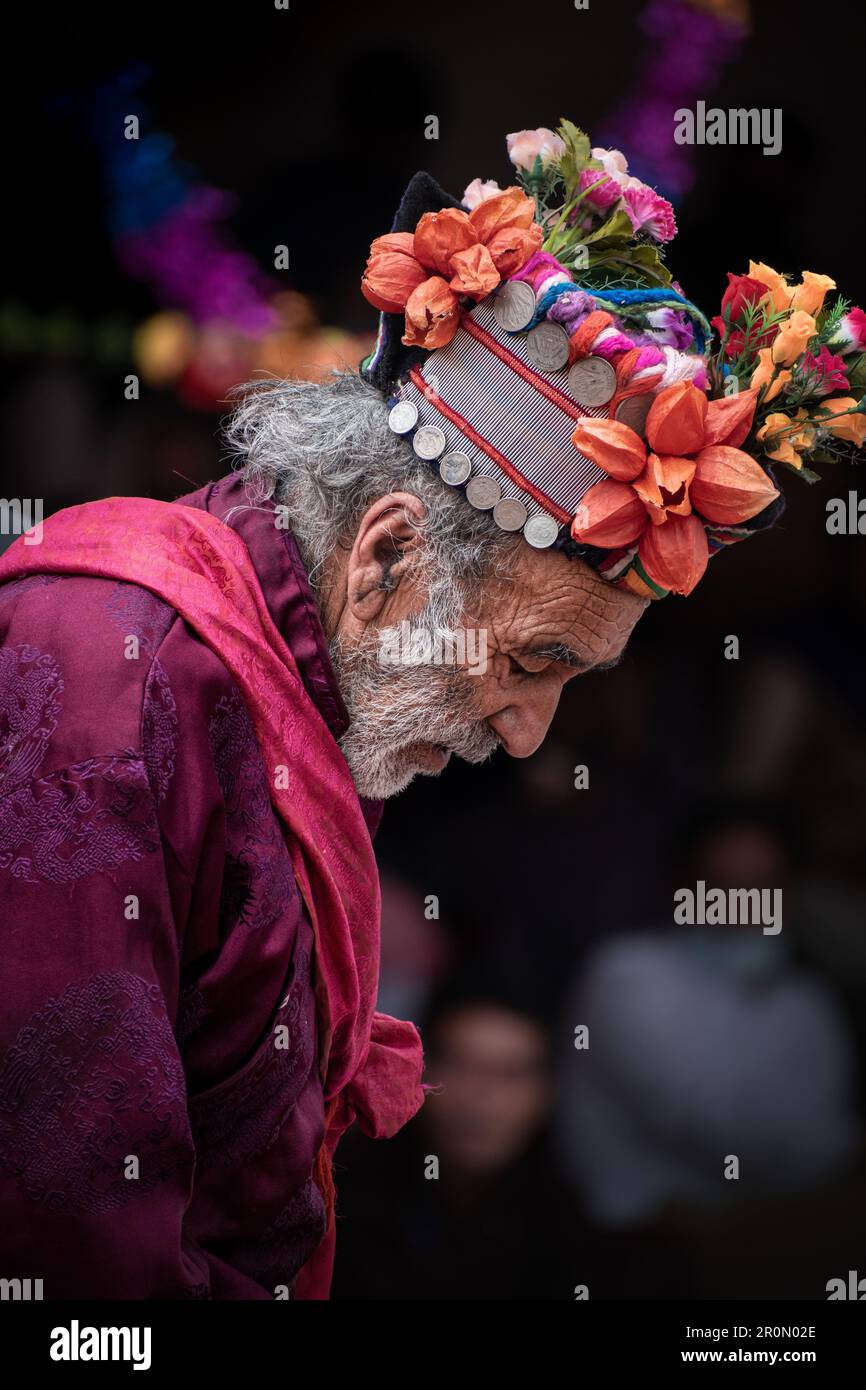 Ein Mann von arischer Herkunft, der ein traditionelles Outfit trägt, dekoriert mit bunten Blumen Stockfoto