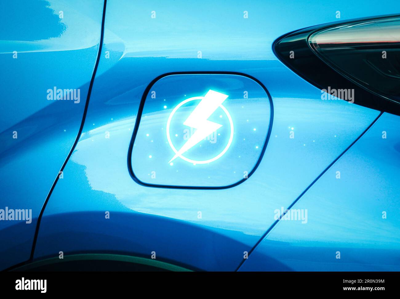 Nahaufnahme eines blauen Elektrofahrzeugs mit Blitzsymbol auf dem Deckel der Ladebuchse auf der Fahrzeugseite, EV-Elektrofahrzeugtechnologie Stockfoto