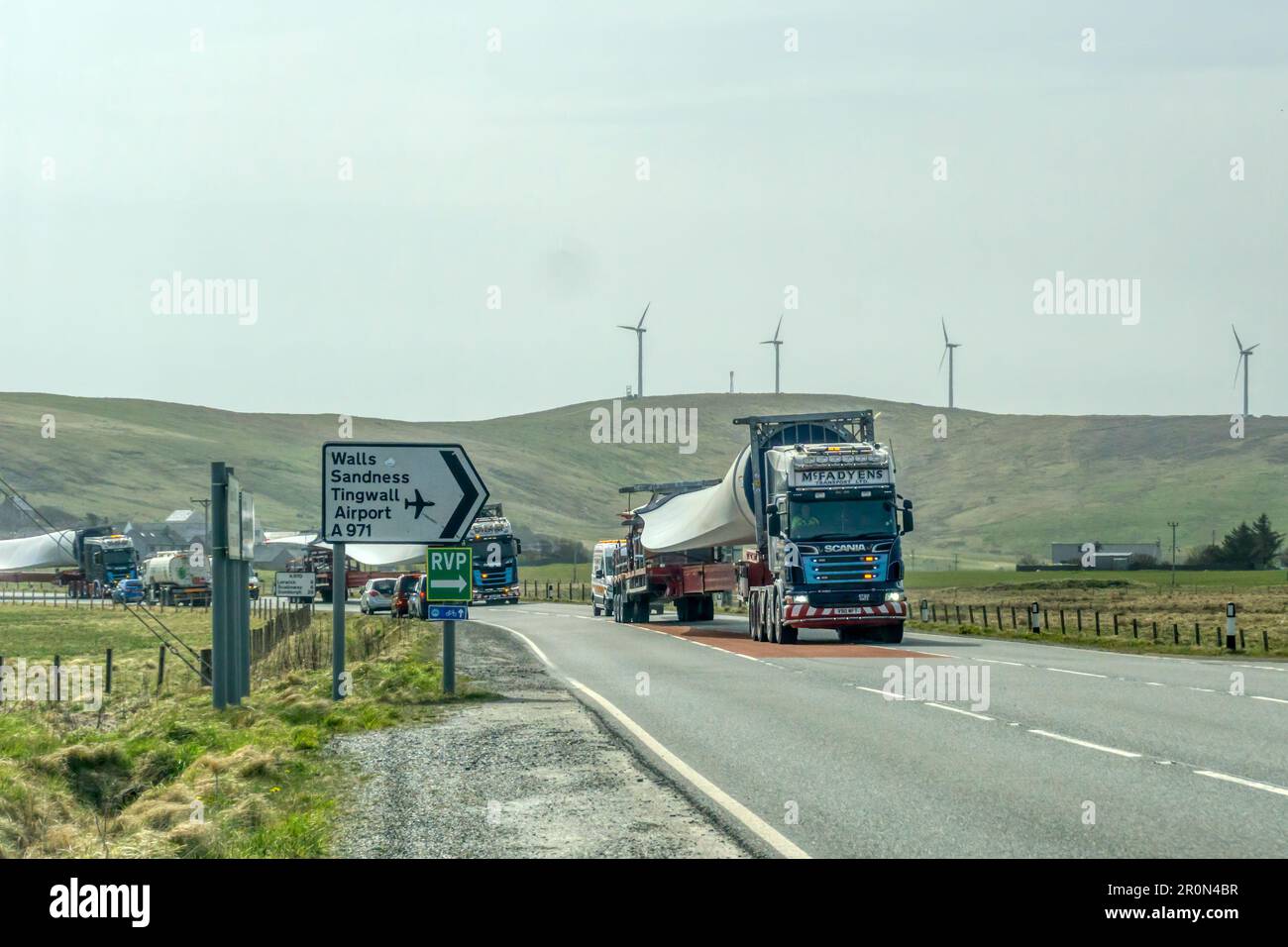 Ein langsam fahrender Konvoi aus Windturbinenschaufeln, der durch das Shetland-Festland fährt, um die Wikinger-Windfarm zu bauen. Stockfoto