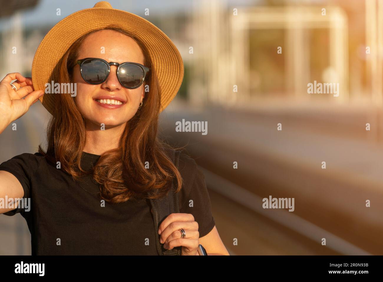 Porträt einer braunen Frau mit gebräunter Haut in Strohhut und Sonnenbrille in der Stadt. Stockfoto