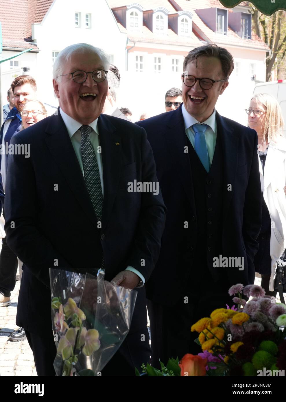 Senftenberg, Deutschland. 09. Mai 2023. Bundespräsident Frank-Walter Steinmeier (l) und Bürgermeister Andreas Pfeifer (CDU) lachen Seite an Seite an einem Blumenstand auf dem Marktplatz. Steinmeier hat seinen offiziellen Wohnsitz für drei Tage nach Senftenberg verlegt. Gespräche mit lokalen Politikern und Bürgern sind geplant. Kredit: Soeren Stache/dpa/Alamy Live News Stockfoto