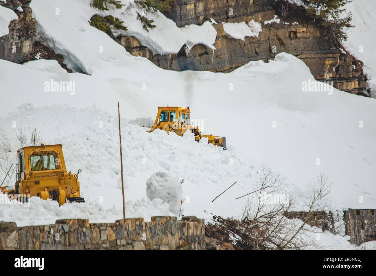 West Glacier, Vereinigte Staaten von Amerika. 24. April 2023. Schneepflug-Crews verwenden schwere Ausrüstung, um auf der Going-to-the-Sun Road während des jährlichen Rodungsvorgangs im Glacier-Nationalpark am 24. April 2023 in West Glacier, Montana, durch tiefe Schneewehen zu pflügen. Die gefährliche Arbeit dauert zehn Wochen, um Schneewehen bis zu 80 Fuß tief im Frühjahr zu entfernen, bevor die Straße wieder geöffnet werden kann. Kredit: Daniel Lombardi/National Park Service/Alamy Live News Stockfoto