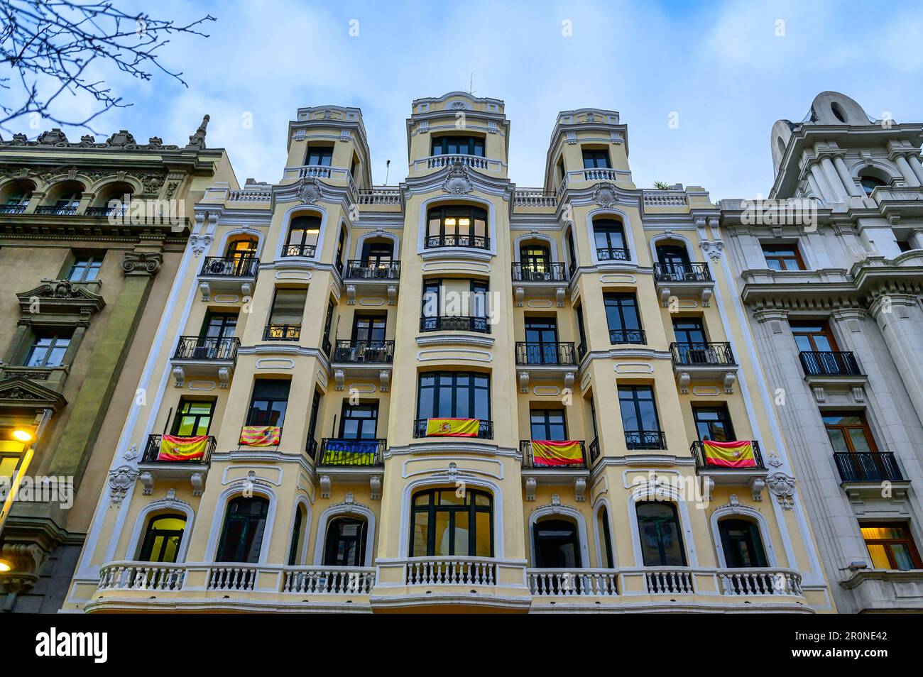 Madrid, Spanien - 26. April 2023: Flacher Blick auf die Fassade eines Gebäudes mit spanischen Flaggen in der Gran Via Stockfoto