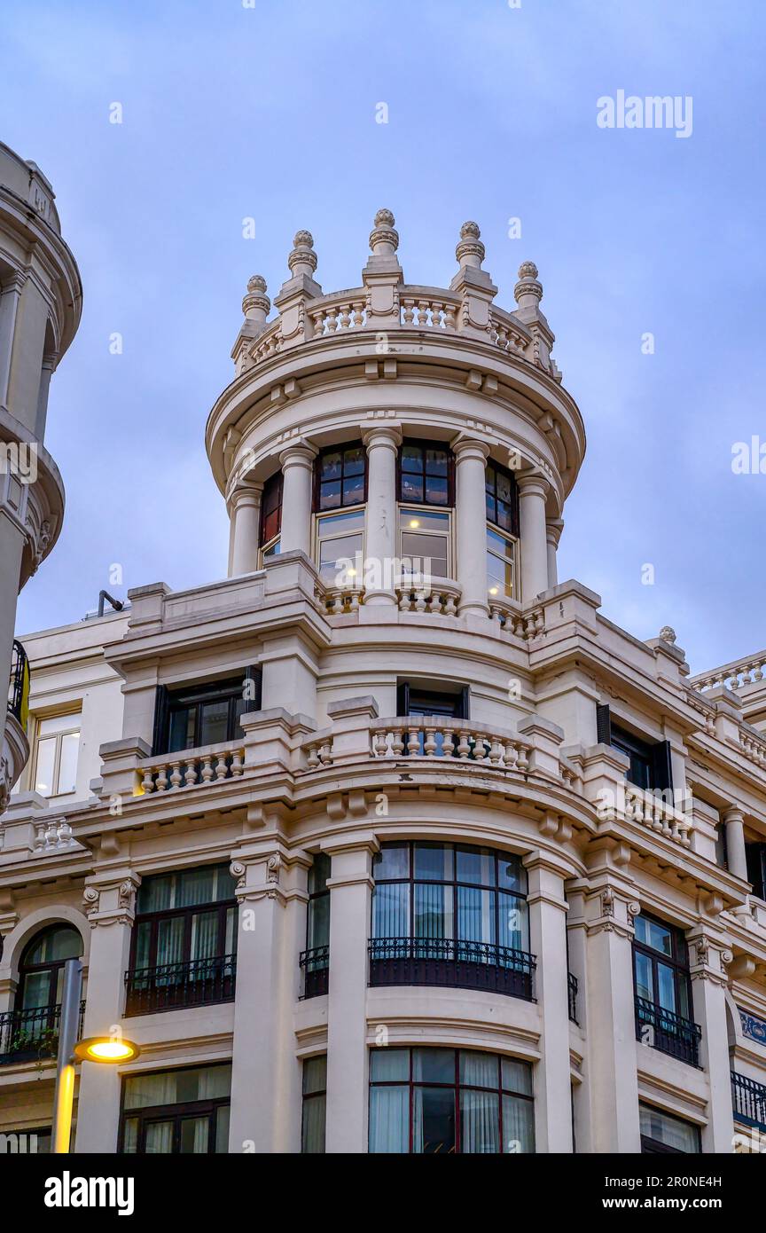 Madrid, Spanien - 26. April 2023: Kreisförmige architektonische Hauptstadt auf einem Gebäude der Gran Via Stockfoto