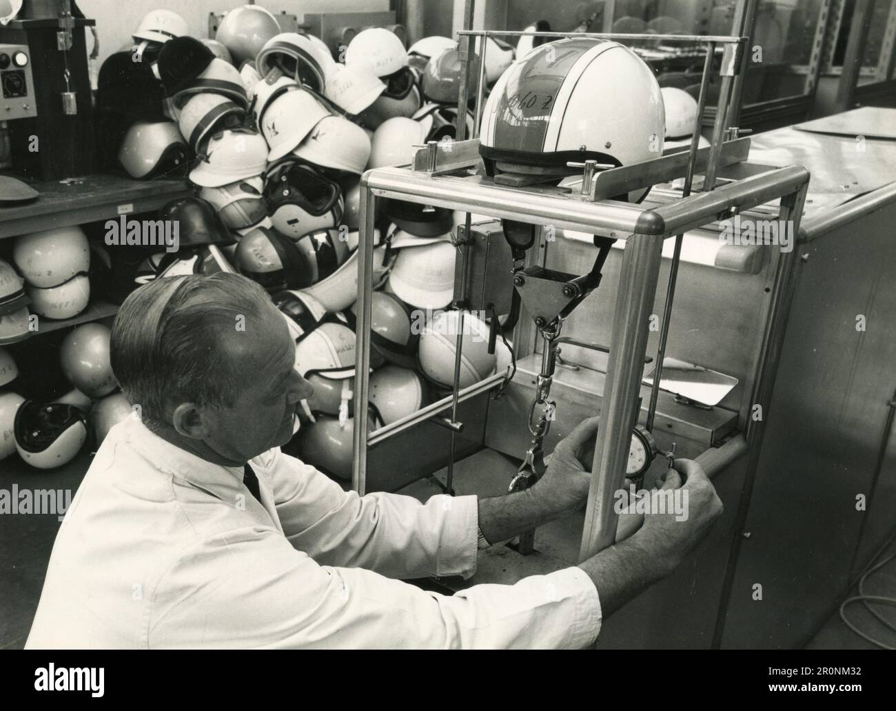 Mann bei der Arbeit an Bruchtests an Crashhelmen an der British Standards Institution, UK 1966 Stockfoto