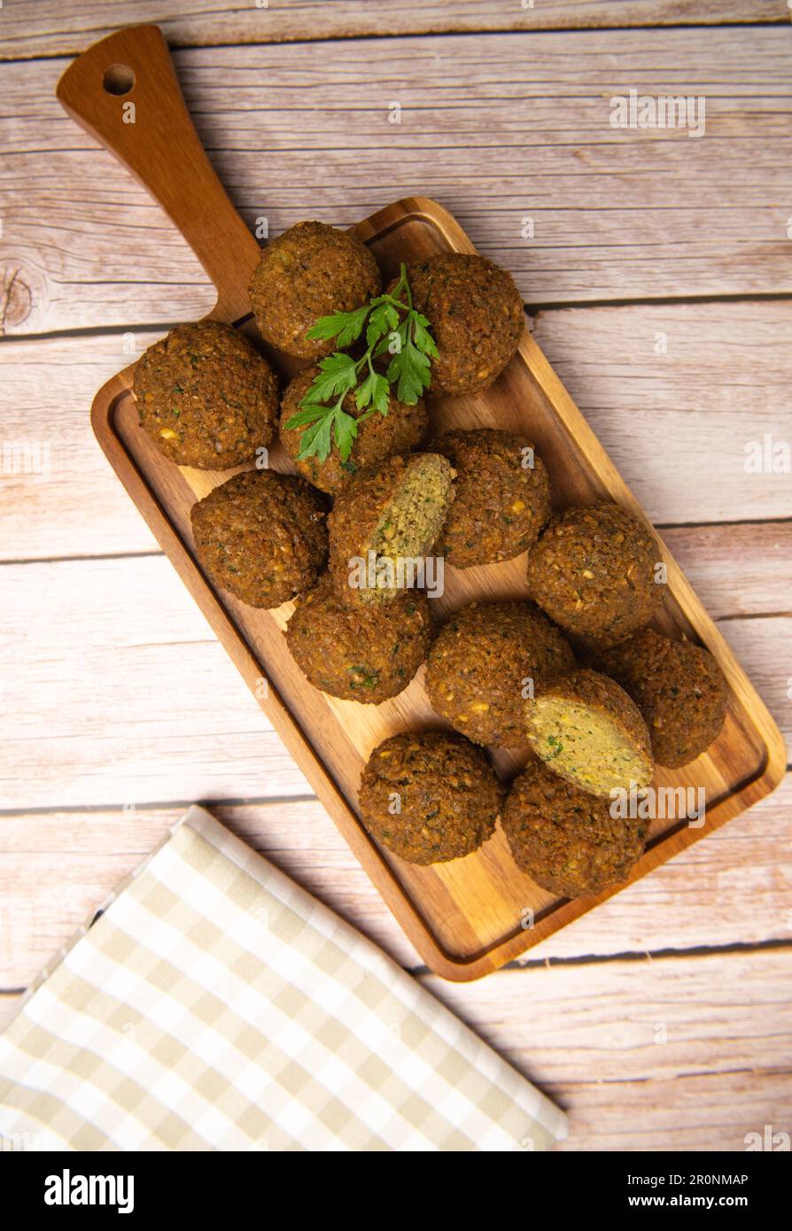 Falafel-Kugeln auf einem Holzbrett und Tahini-Sauce Stockfoto