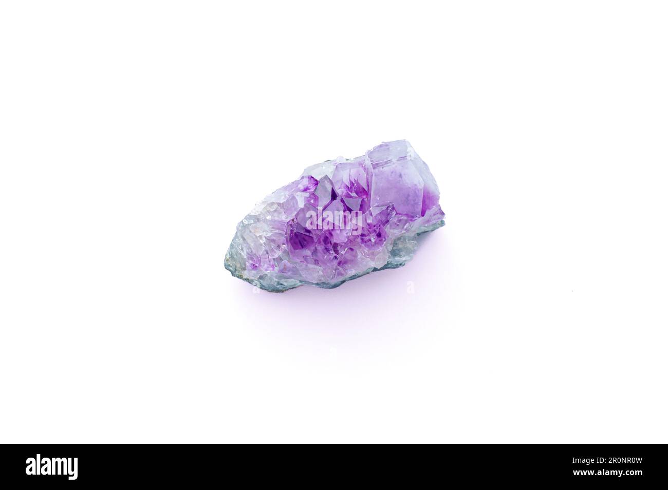 Amethyst Stone Makro Detail Texturhintergrund. Violett, violett, rosa, roher, unpolierter Schmuckstein aus nächster Nähe. Isoliert auf weiß Stockfoto