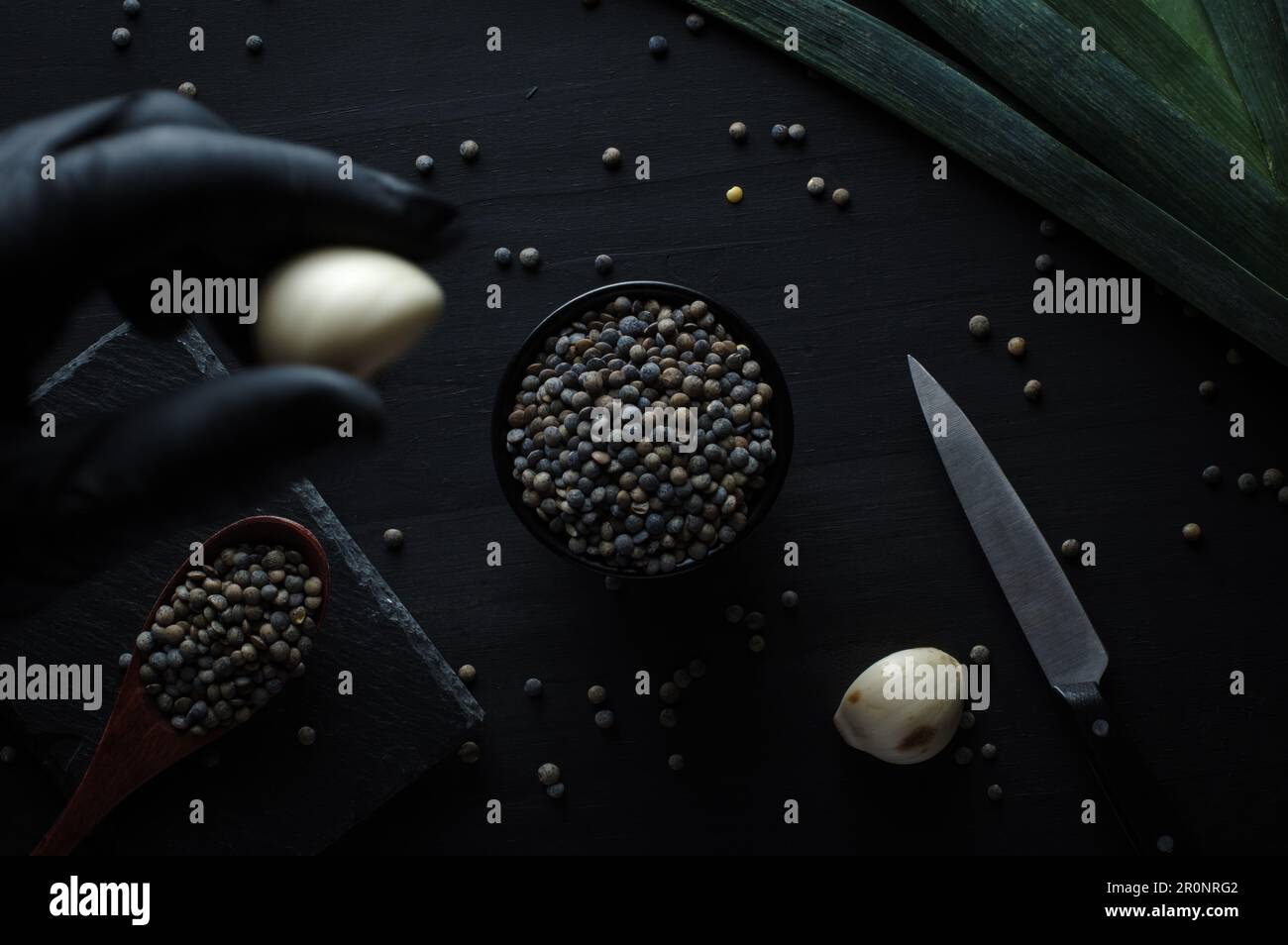 Französische grüne Linsen (le puy Green lentils g.U., AOC) (Lens esculenta puyensis ) mit Lauch Draufsicht Makrodetails Hintergrund Nahaufnahme roh, roh, Backd Stockfoto