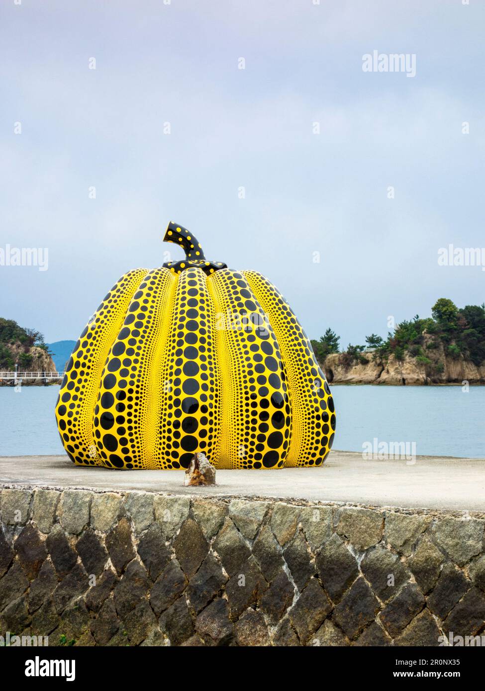 Gelbe Kürbisskulptur des japanischen Künstlers Yayoi Kusama auf der Insel Naoshima, Japan. Die Insel beherbergt eine Sammlung zeitgenössischer Kunst, die m ist Stockfoto