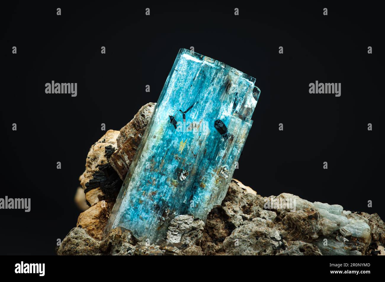 Blaues Aquamarin mit Schorl (schwarzes Turmalin). Texturhintergrund für Makrodetails. Nahaufnahme von rohem, unpoliertem Halbedelstein Stockfoto