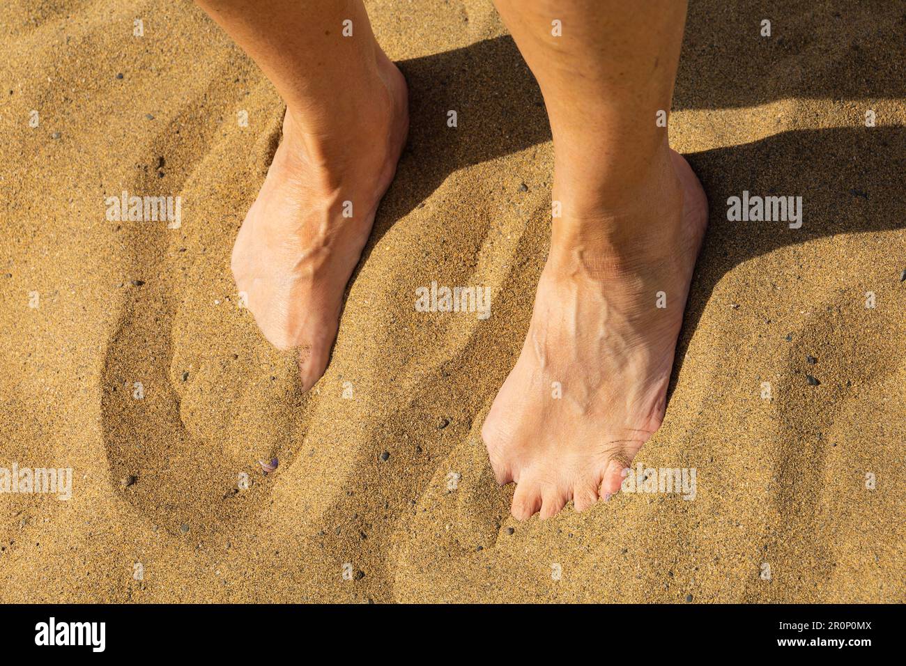 Weibliche Füße im Sand am Strand von Maspalomas. Las Palmas, Gran Canaria, Spanien Stockfoto