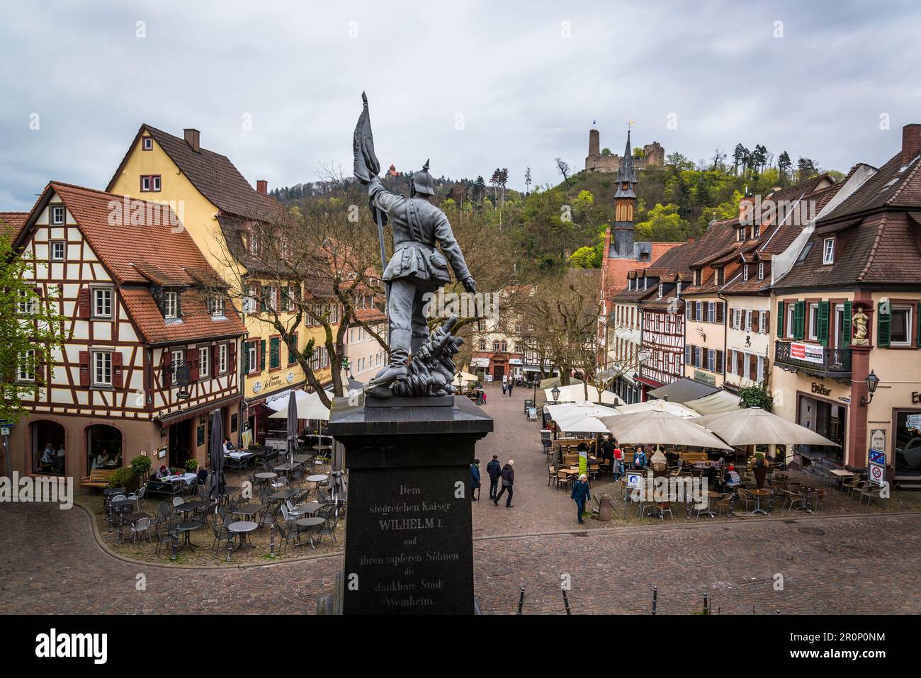 Ein Kriegsdenkmal, der Marktplatz mit traditioneller mittelalterlicher Architektur und das Schloss Windeck, Weinheim, Baden-Württemberg, Deutschland Stockfoto