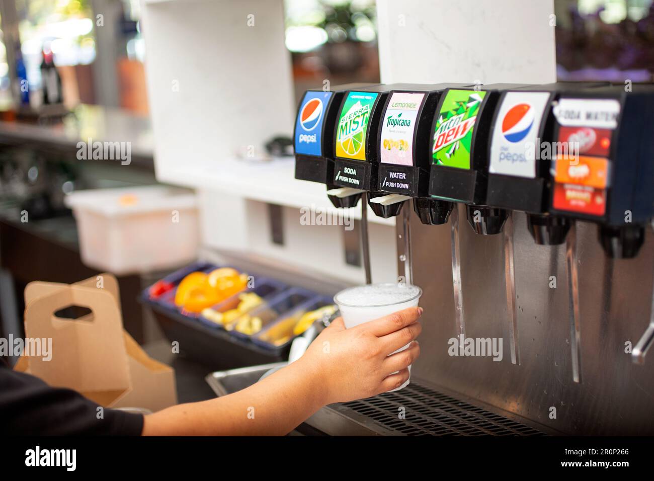 Los Angeles, Kalifornien, USA - 09-23-2021: Blick auf eine Hand, die einen Becher mit Soda aus einem Pepsi-Soda-Brunnen in einem Restaurant füllt. Stockfoto