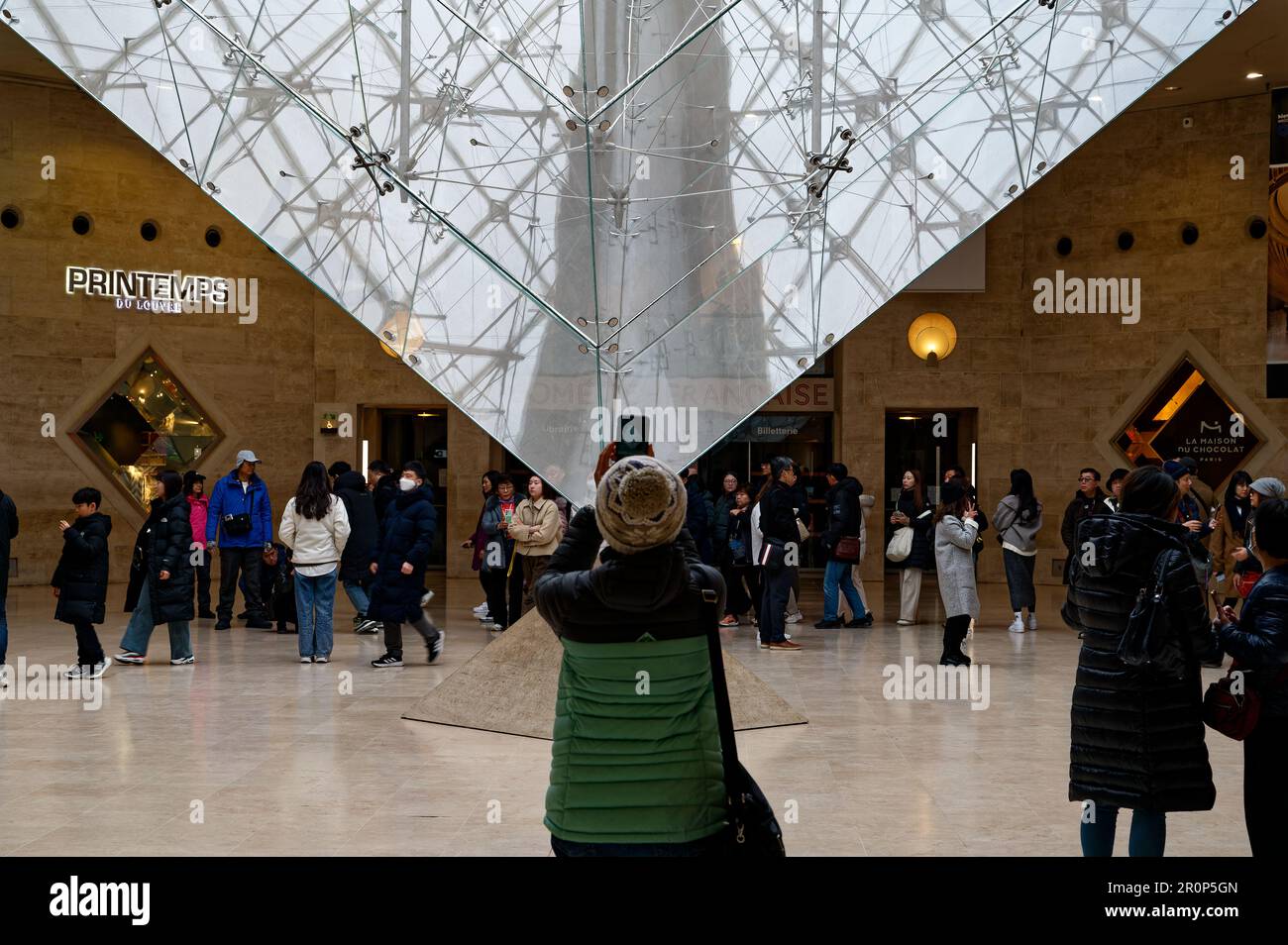 Touristen versuchen, den besten Winkel der umgekehrten Pyramide am Eingang zum Louvre Museum zu bekommen Stockfoto