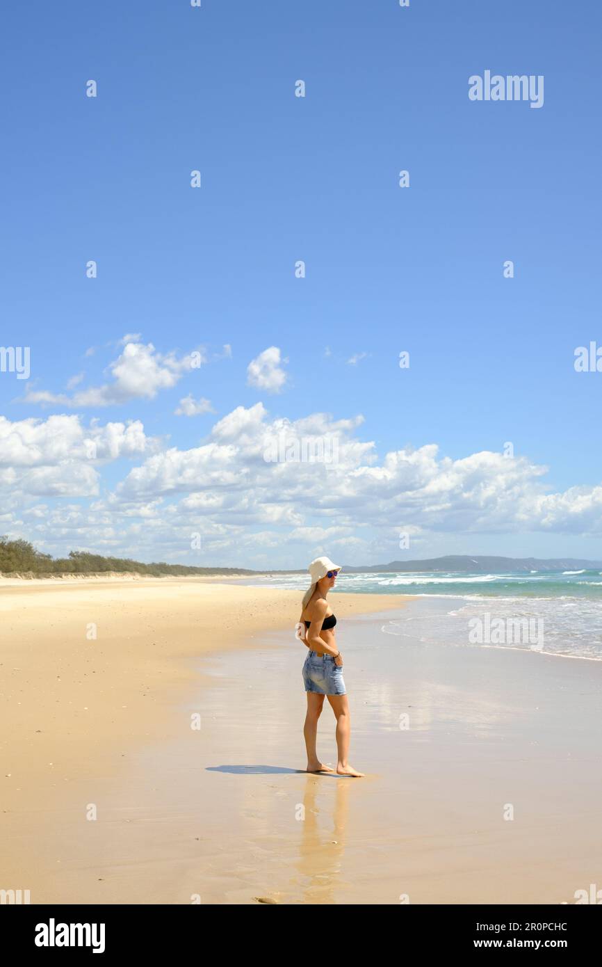 Eine junge Frau mit Strohhut und Blick auf den weiten Ozean, Noosa North Shore Beach, Australien Stockfoto