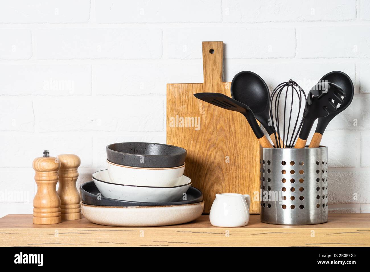 Küchentisch, Küchenutensilien, Teller, Schüsseln, Schüttler und  Holzschneidebrett Stockfotografie - Alamy