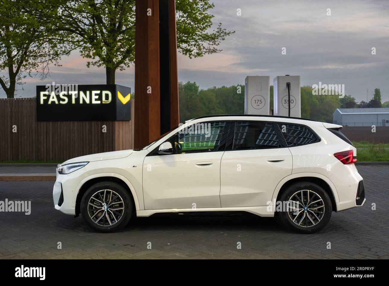 Roosendaal, Niederlande - Mai 6 2023: Fastned öffentliche Schnellladestation lädt einen BMW IX1 auf der Autobahn A58 in der Nähe der Stadt Roosendaal. Stockfoto