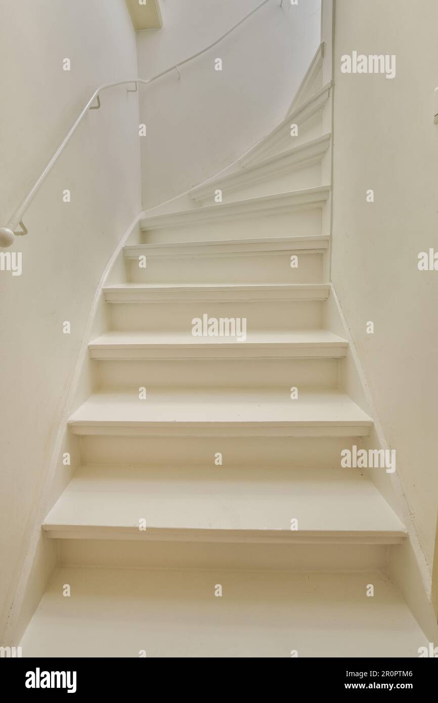 Einige weiße Treppen in einem Zimmer, in dem niemand auf der Treppe ist, und es gibt einen Blick von oben auf die Treppe Stockfoto
