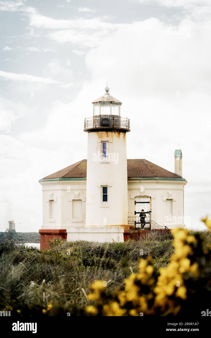 Coquille River Lighthouse in Bandon, Oregon, USA, im Bullards Beach State Park an der Küste von Oregon, PNW, am Tag des hell bedeckten Tages. Vertikales Bild der Frau oben Stockfoto