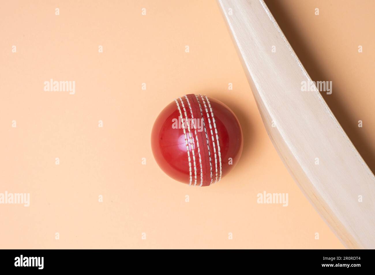 Cricketschläger und rote Bälle auf grünem Hintergrund. Horizontales Sportposter, Grußkarten, Kopfzeilen, Website und App Stockfoto