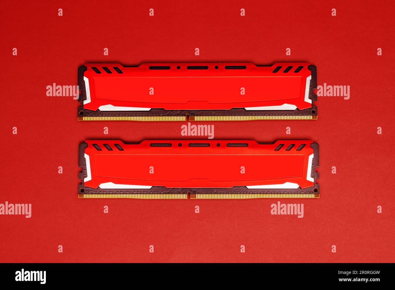 DDR4-RAM-Speicherkarten mit roten Aluminiumkühlkörpern auf einer farblich passenden Oberfläche Stockfoto