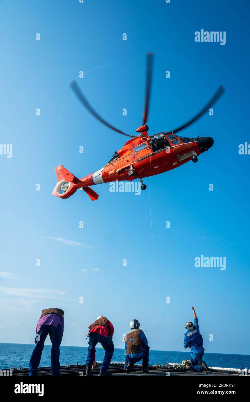 Verzurrung an Bord der USA Coast Guard Cutter Active (WMEC 618) Bereiten Sie den Einsatz eines Kraftstoffschlauchs für einen Airbus MH-65 Helikopter im östlichen Pazifik vor, 17. März 2023. Active führte während des Fluges eine Betankungsübung durch, bei der der Hubschrauber über dem Deck schweben und Kraftstoff vom Schiff erhält. (USA Foto der Küstenwache von Petty Officer 2. Class Justin Upshaw). Stockfoto