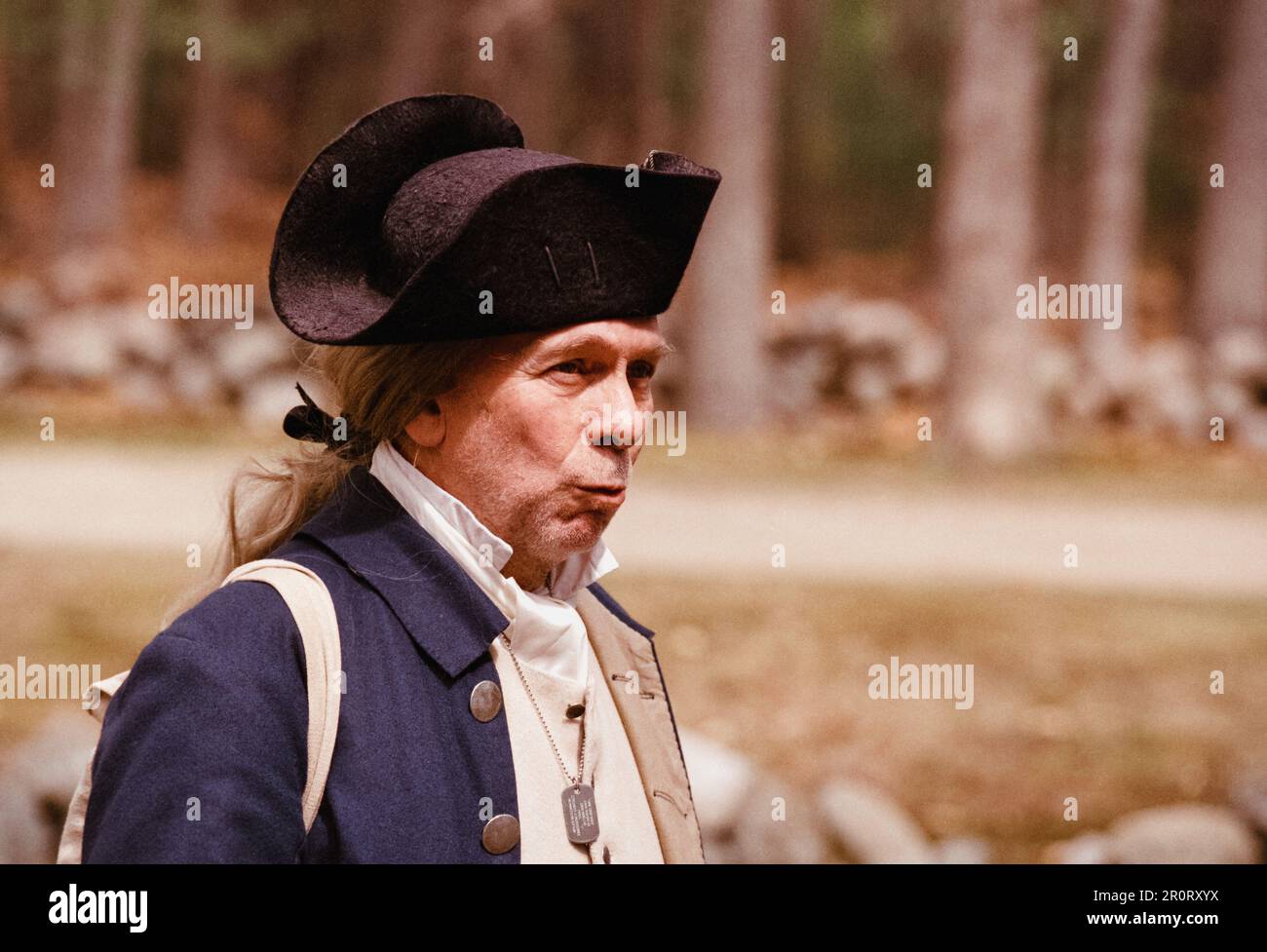 Lexington, Massachusetts, USA - April 2023 - ein Schauspieler aus der Kolonialbekleidung pfeift, während er im Minuteman National Historical entlang der Battle Road spaziert Stockfoto