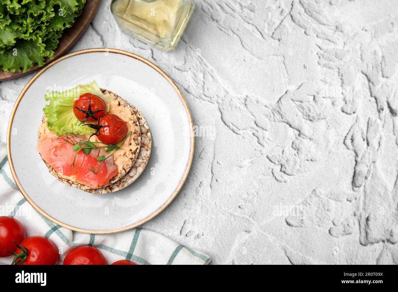 Knusprige Buchweizenkuchen mit Lachs, Tomaten und Gemüse auf weißem ...