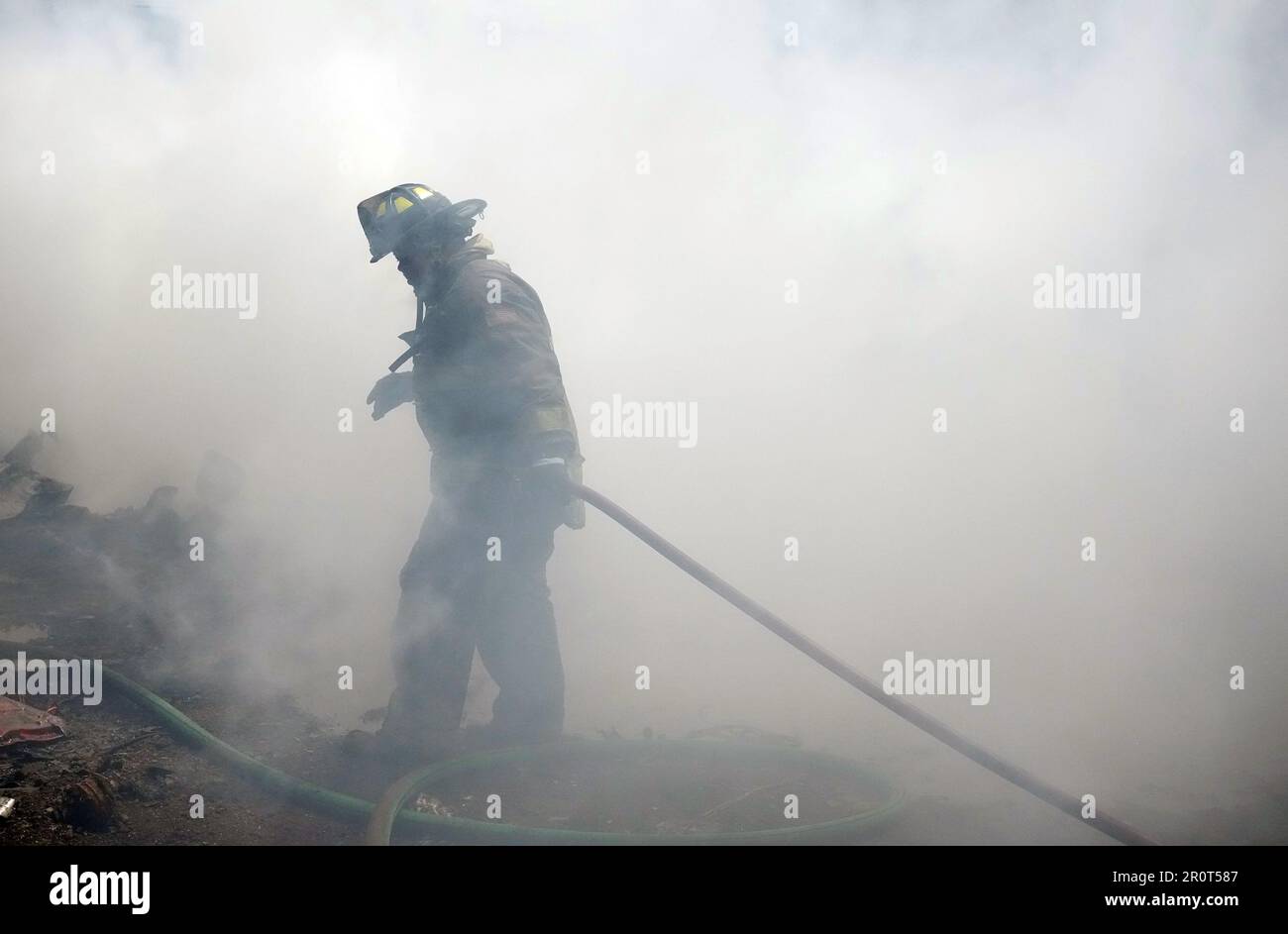 St. Louis, Usa. 09. Mai 2023. Ein St. Der Feuerwehrmann von Louis durchquert dichten Rauch bei einem hartnäckigen Brand auf dem Schrottplatz, der durch Benzin- und Magnesiummotorblöcke in St. angetrieben wird Louis am Dienstag, den 9. Mai 2023. Foto: Bill Greenblatt/UPI Credit: UPI/Alamy Live News Stockfoto