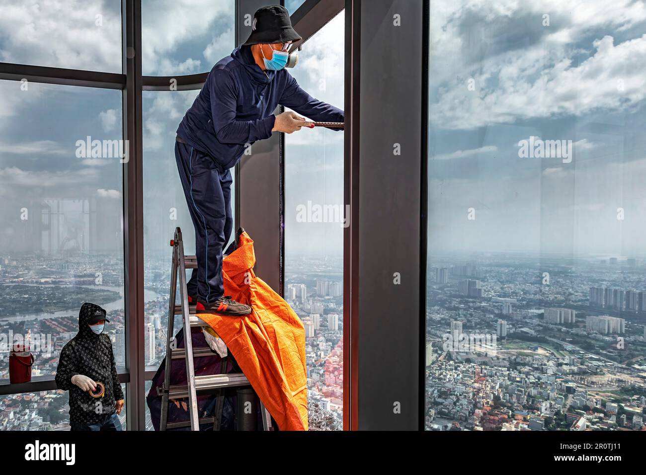 Vietnamesische Arbeiter ersetzen zerbrochene Glasfenster im Landmark 81 Tower, Ho Chi Minh City, Vietnam Stockfoto