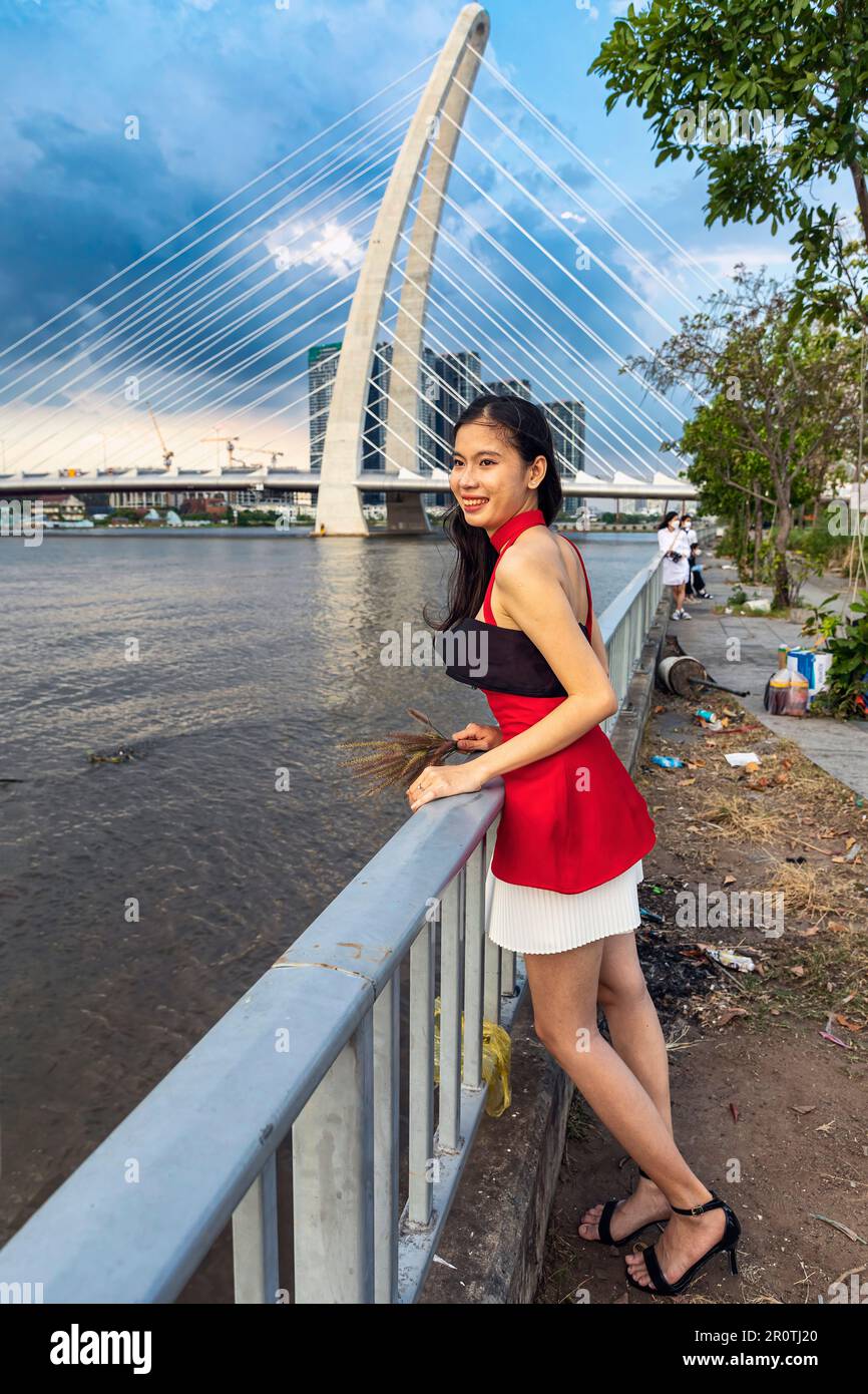 Attraktives vietnamesisches Mädchen, das vor der Thu Thiem Brücke am Saigon River posiert, Ho Chi Minh City, Vietnam Stockfoto
