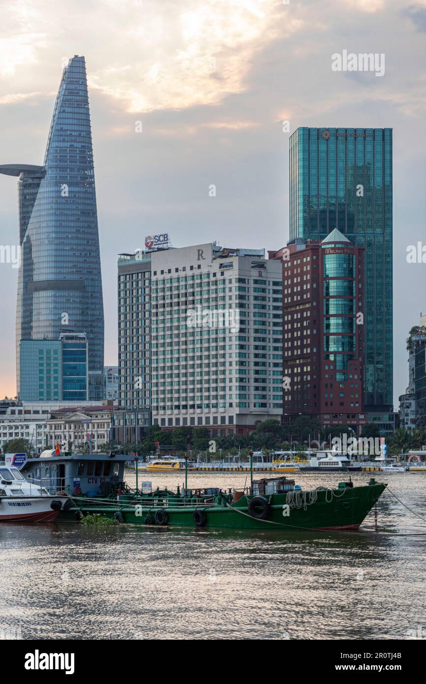 Boote auf dem Saigon River vor Wolkenkratzern und der Skyline des Gebäudes, Ho-Chi-Minh-Stadt, Vietnam Stockfoto