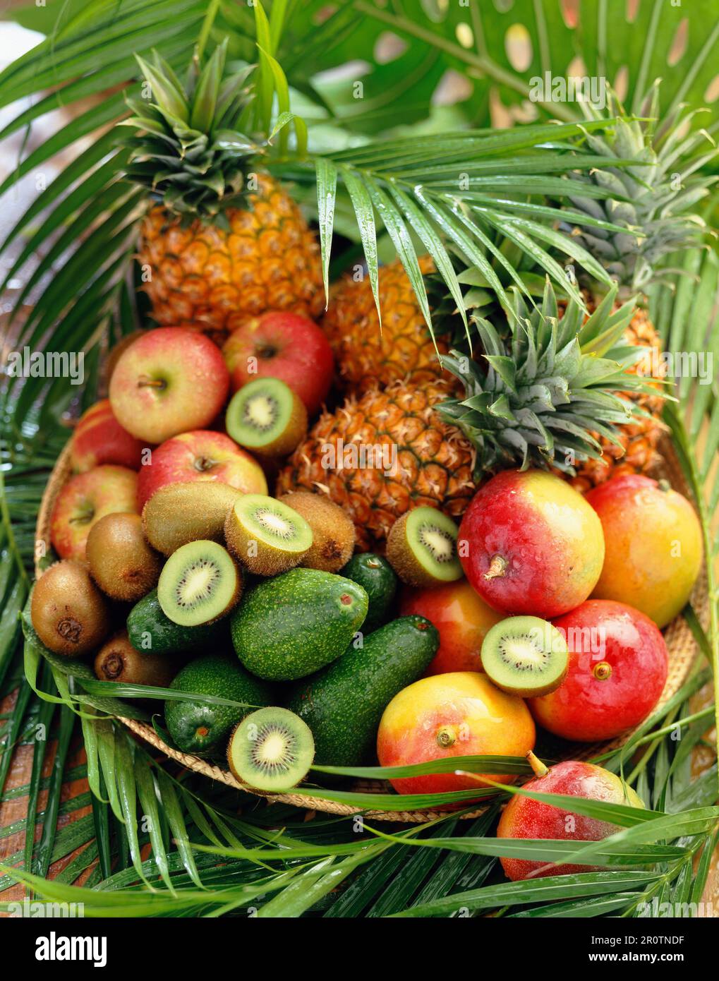 Korb mit exotischen Früchten und Blättern Stockfoto