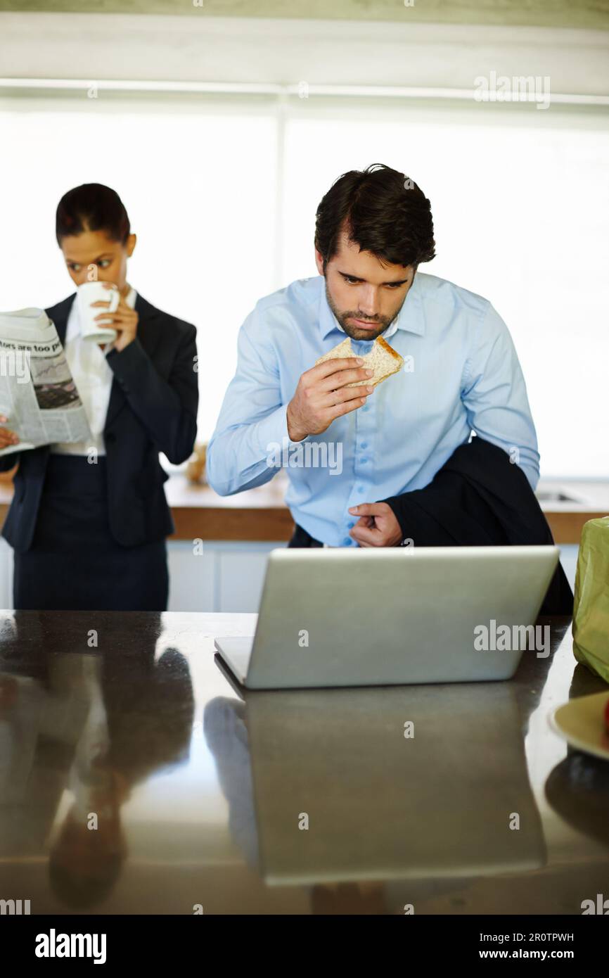 Geschäftspaare haben das Frühstück gehetzt. Ein attraktives Geschäftspaar, das schnell frühstückt. Stockfoto