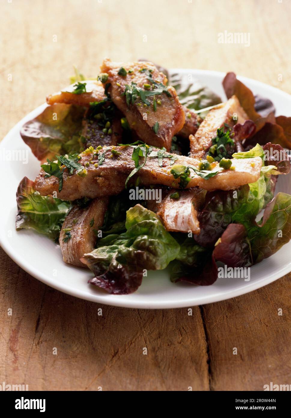 In der Pfanne gebratener Karpfen und Pistaziensalat Stockfoto