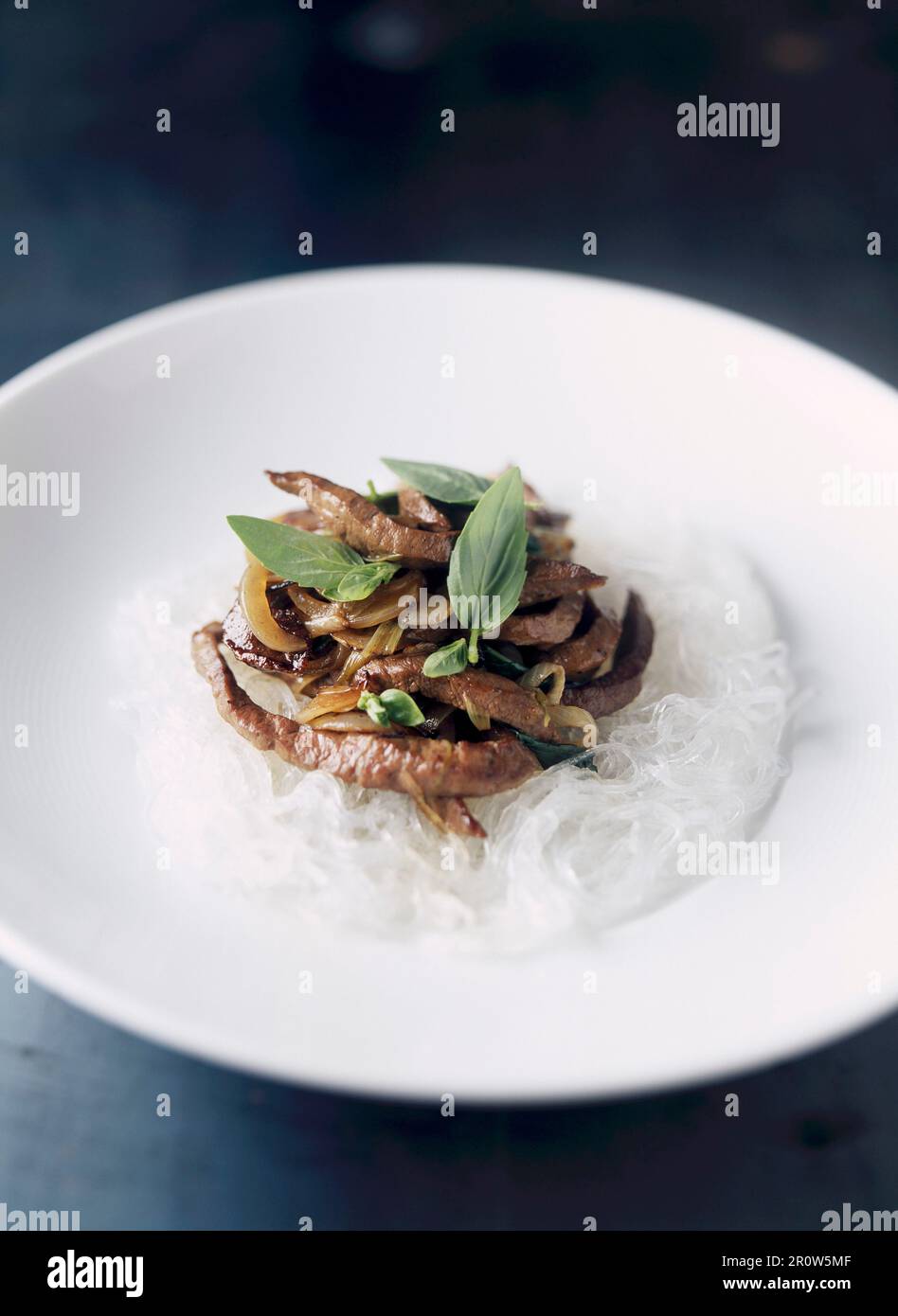 Rindfleisch mit thailändischem Basilikum auf einem Bett aus Reisvermicelli Stockfoto