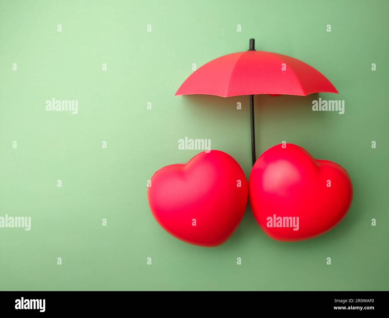 Rotes Herz und Schirm auf grünem Hintergrund Stockfotografie - Alamy