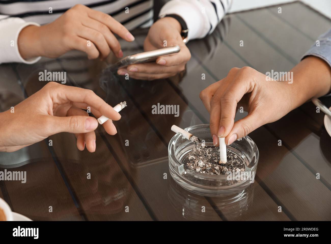 Frau, die Zigaretten im Aschenbecher am Tisch ausstellt, schließt  Stockfotografie - Alamy