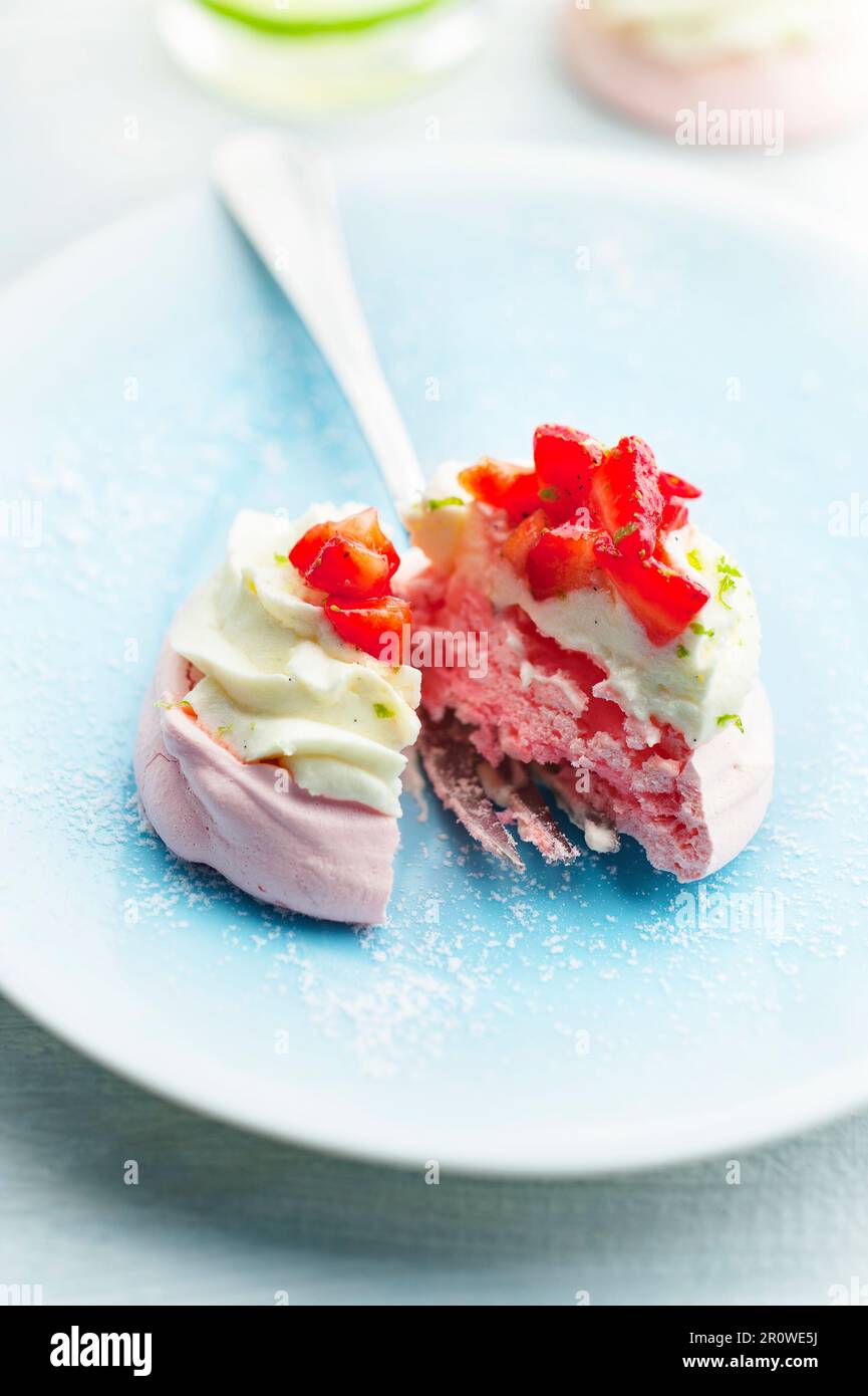Erdbeer-Baiser und Schlagsahne mit Limettenschalen Stockfoto