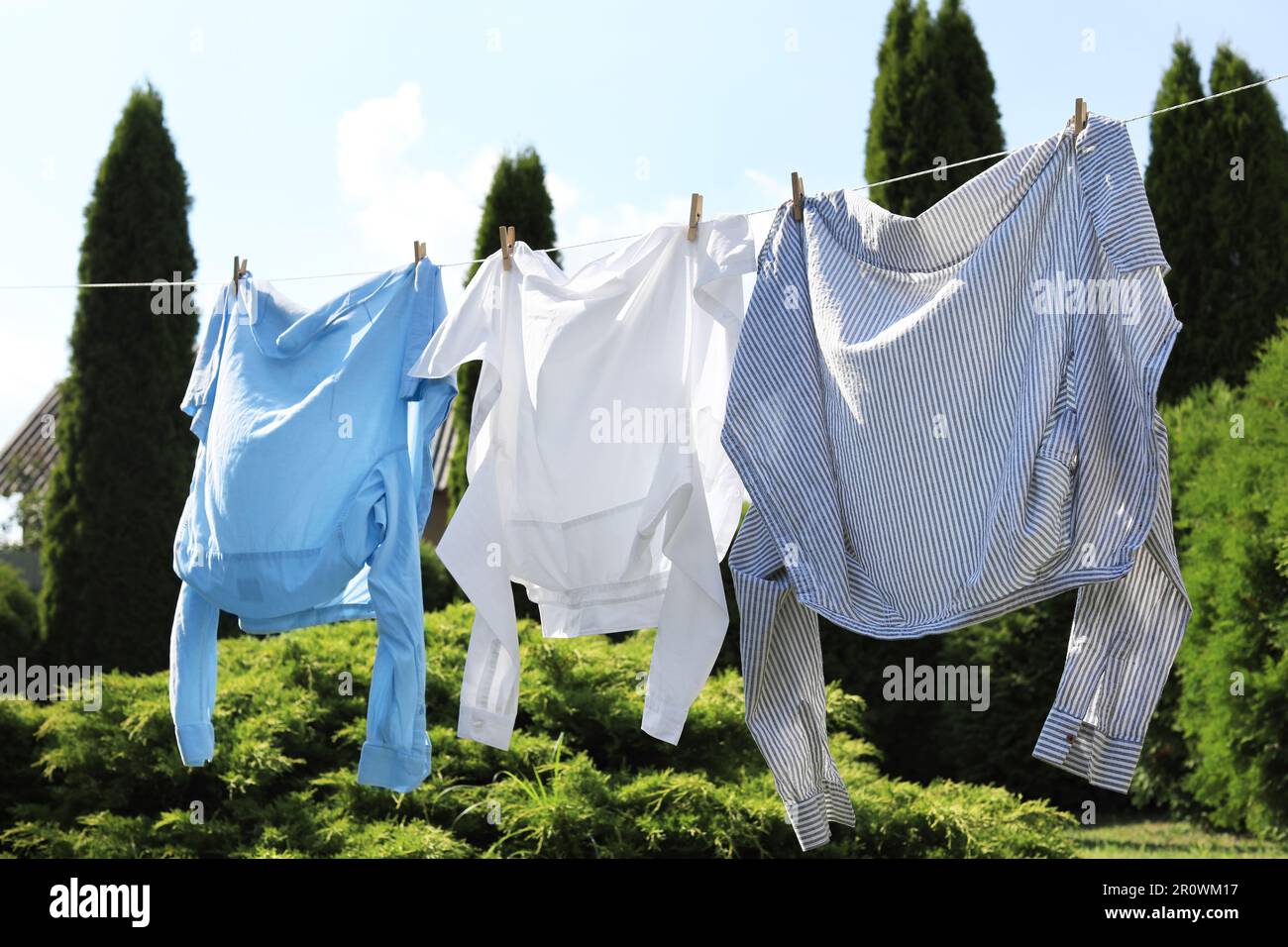 Saubere Wäsche hängt im Garten an der Wäscheleine. Wäschetrockner Stockfoto