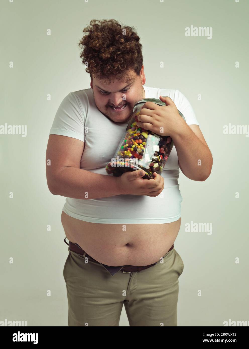 Mein Schatz. Ein übergewichtiger Mann, der sein Leben lang an seinen Süßigkeiten festhält. Stockfoto